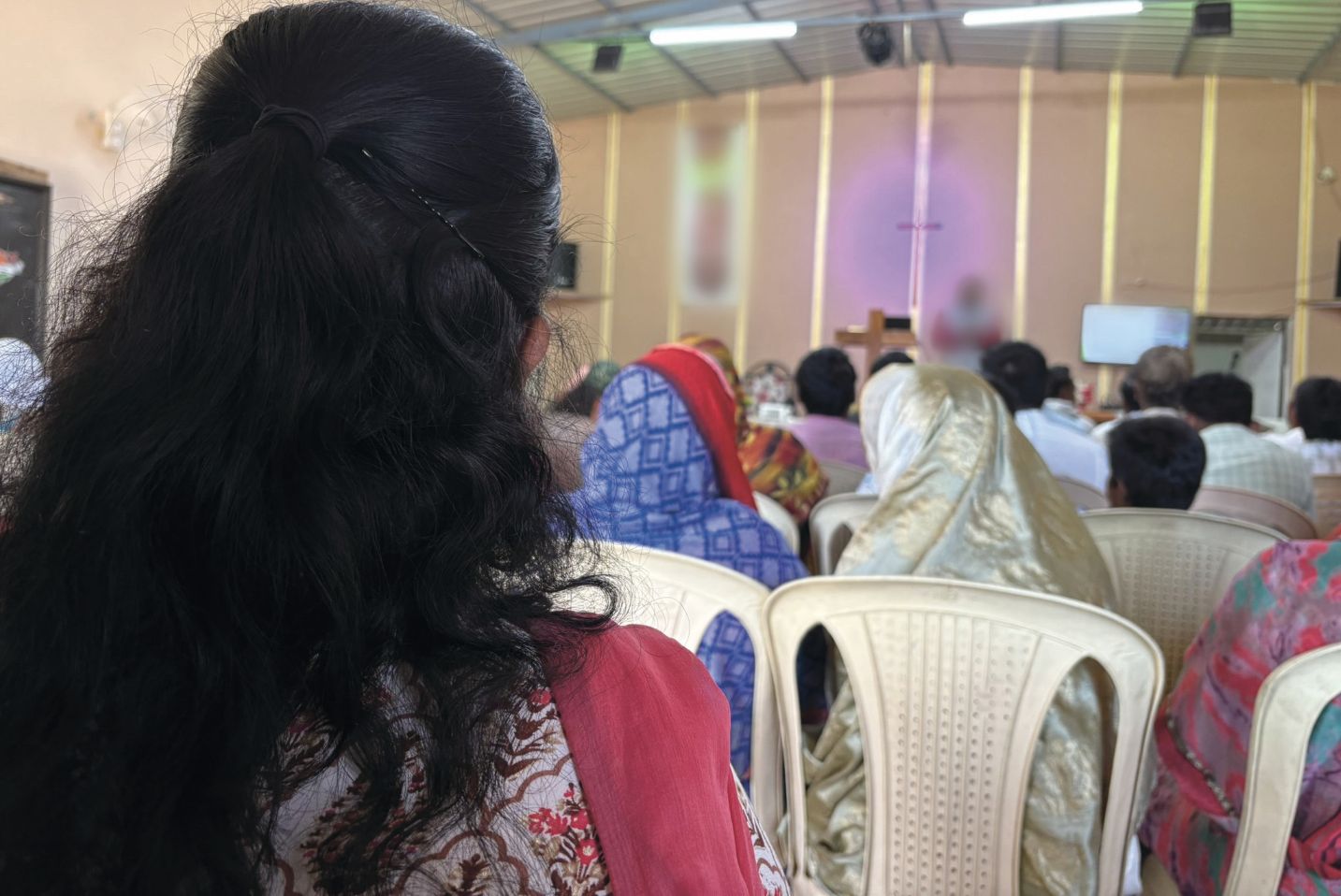 Žena a další lidé v kostele.